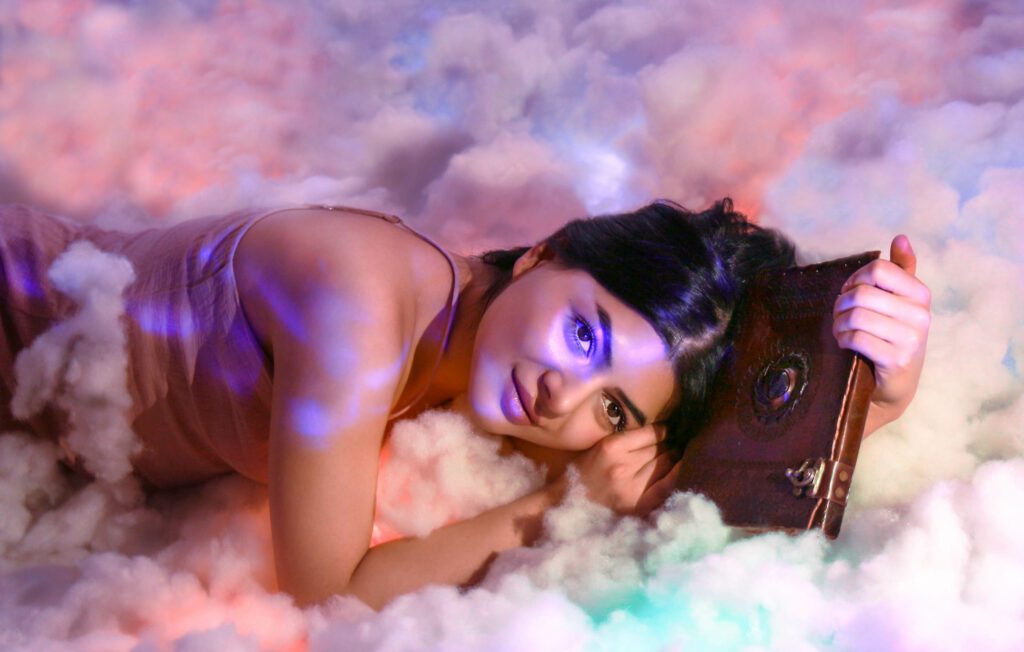 Fantasy Foto, eine Frau liegt mit einem Buch in den Wolken